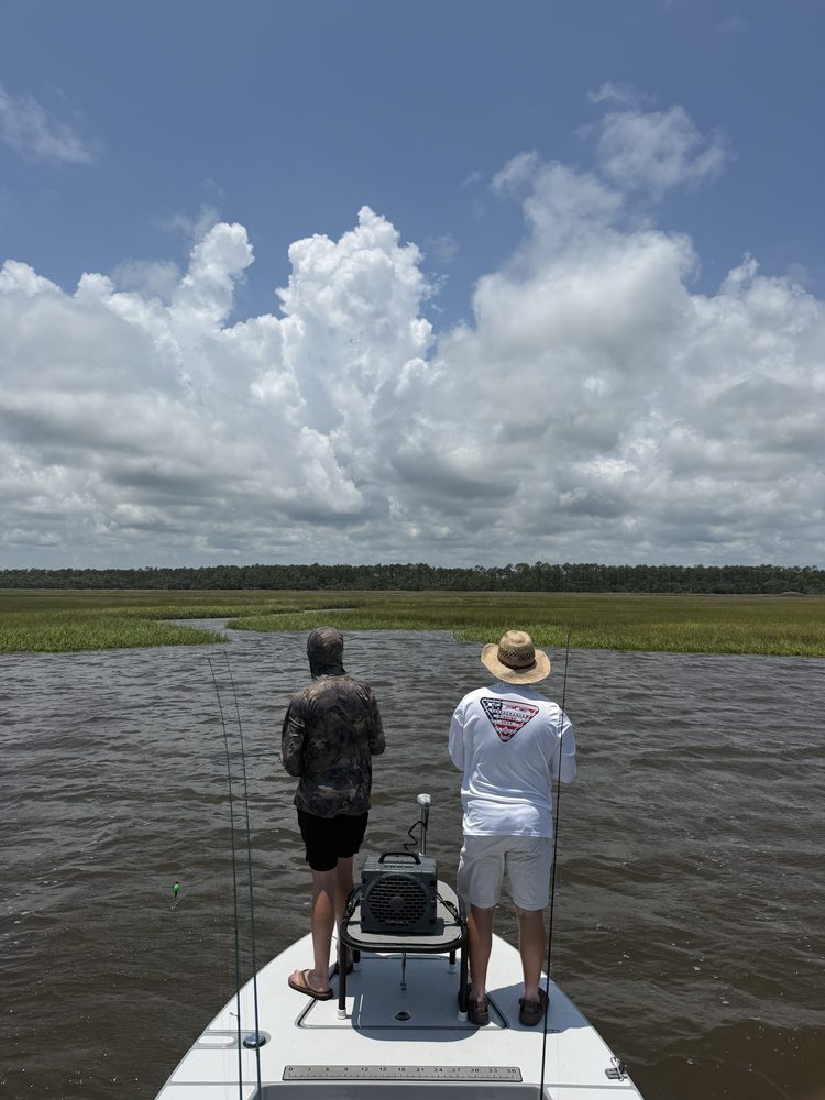 Two anglers casting from the bow of the skiff toward a Palm Valley marsh