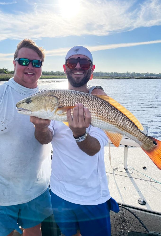 Two anglers holding a redfish