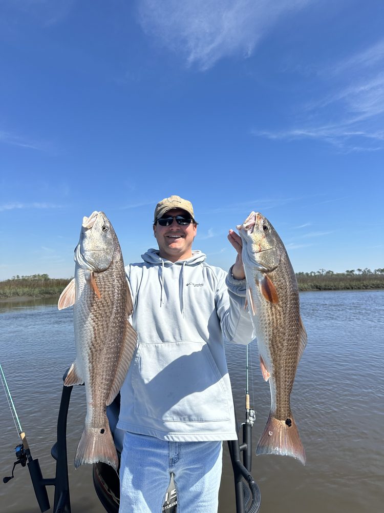 Angler holding two redfish on the Intracoastal
