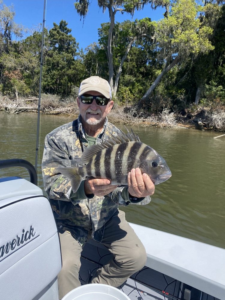 Angler holding a sheepshead beside the skiff