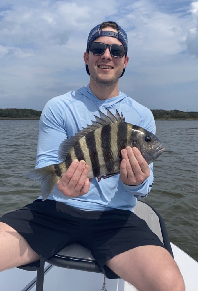 Angler on the skiff holding a sheepshead