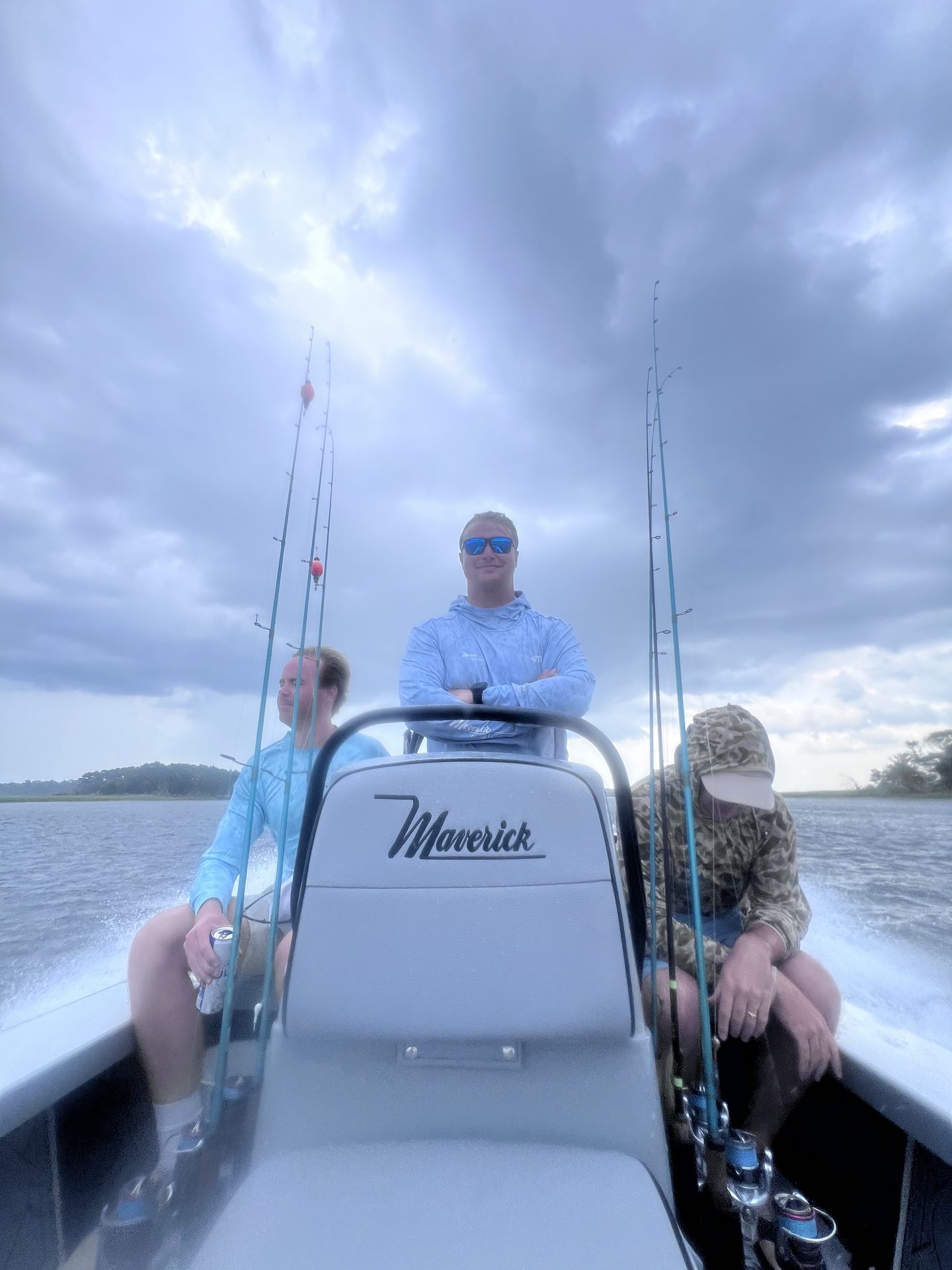 Captain Wills Hardegree at the console of the Maverick skiff with two anglers aboard